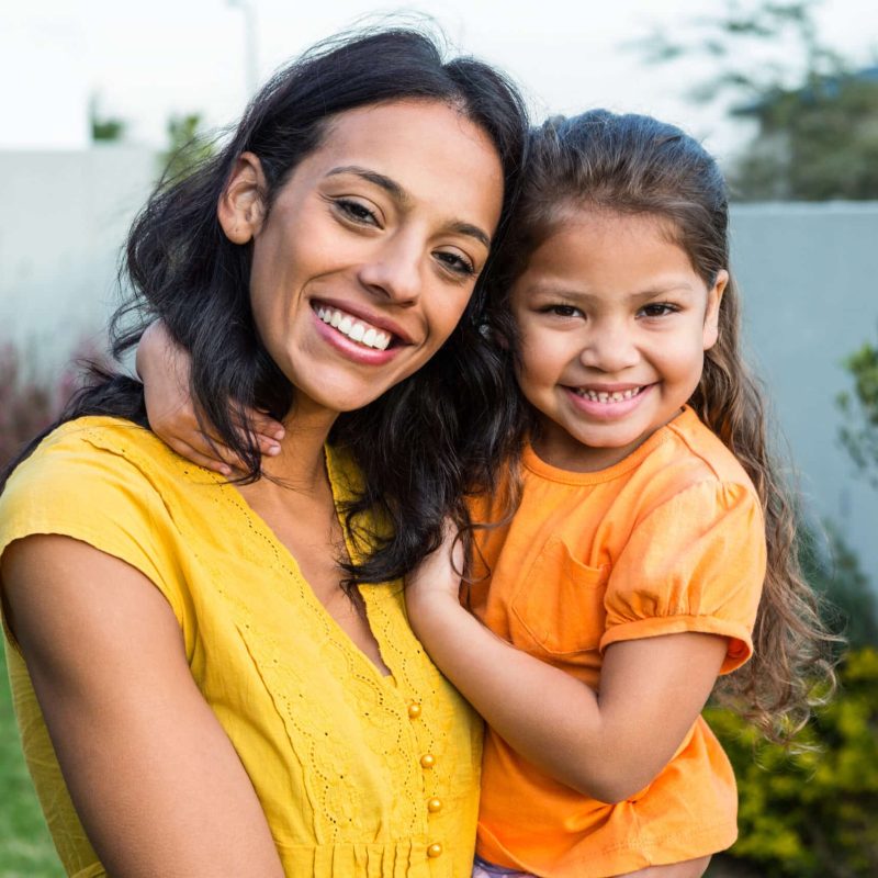 Standing,Mother,Holding,Her,Daughter,Outdoors,Posing,For,The,Camera